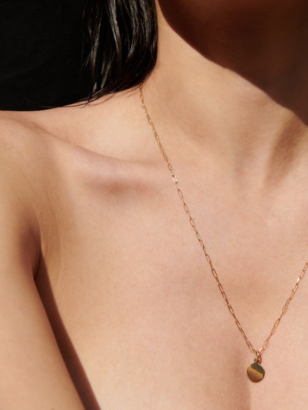 Mini Disk Pendant strung on Long Link Chain, shot on model.