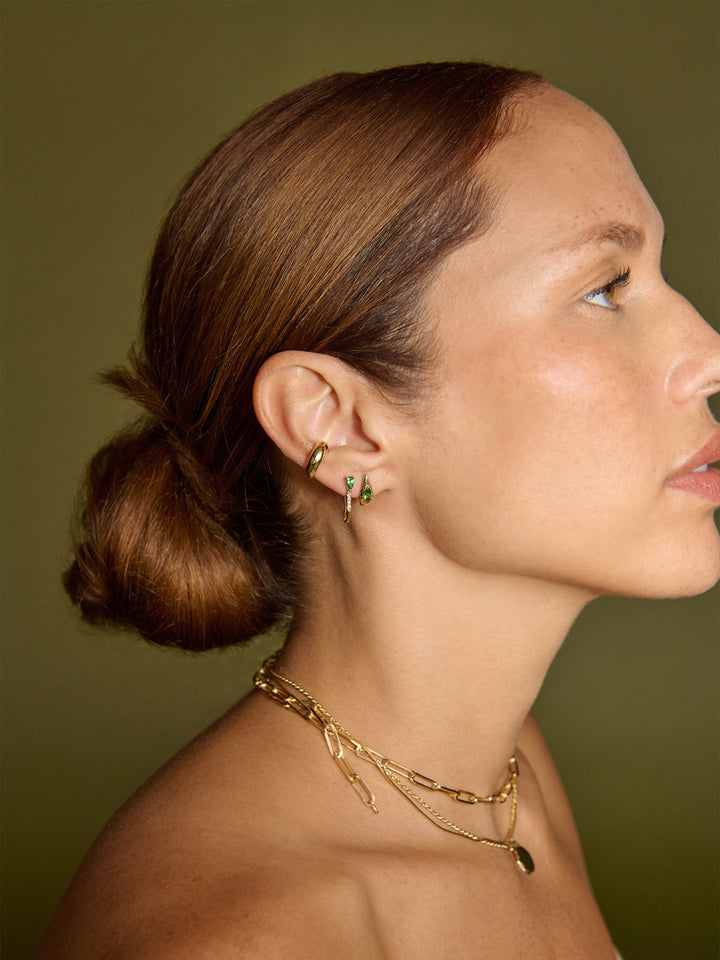 14kt Yellow Gold Mini Diamond Tsavorite Safety Pin pictured in models first piercing. 