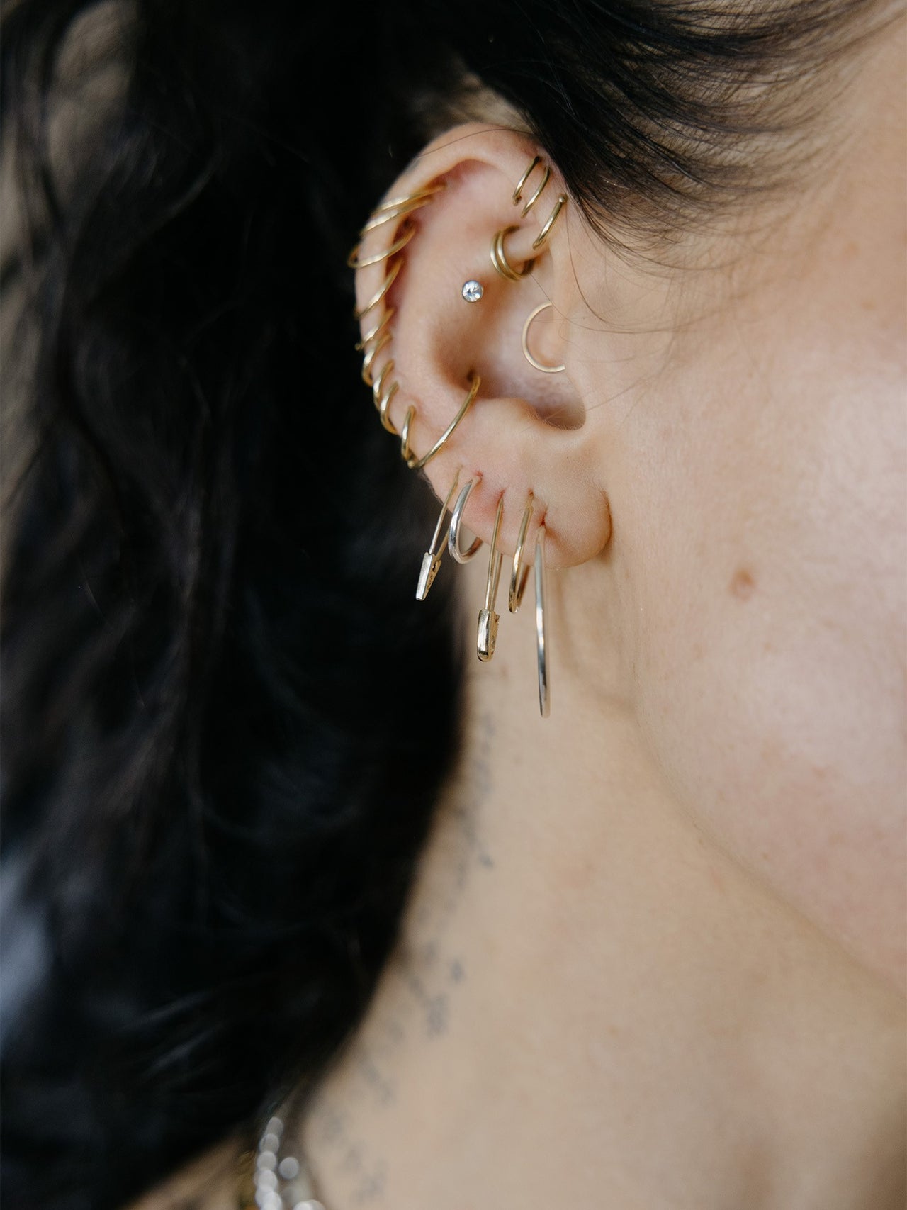 Mini Infinity Hoops pictured in models second piercing. Styled with other signature styles.