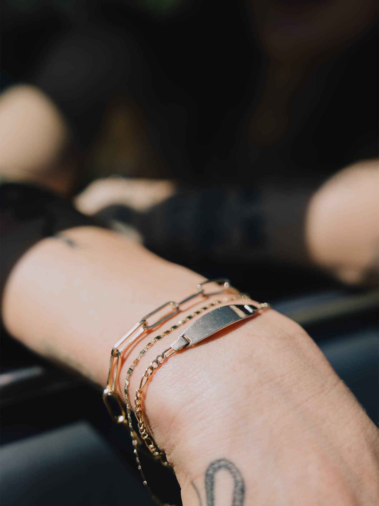 Mini Ellipse ID Bracelet pictured on models wrist. Layered with the XL Boxy Long Link and Sol Valentino Bracelets.