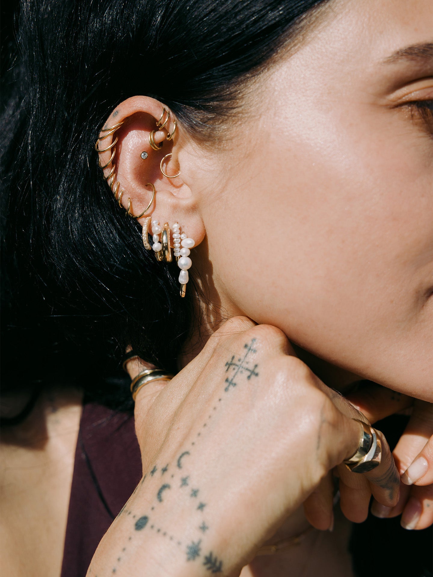 14kt Yellow Gold Baby Pave Hoops pictured in models fourth piercing. 