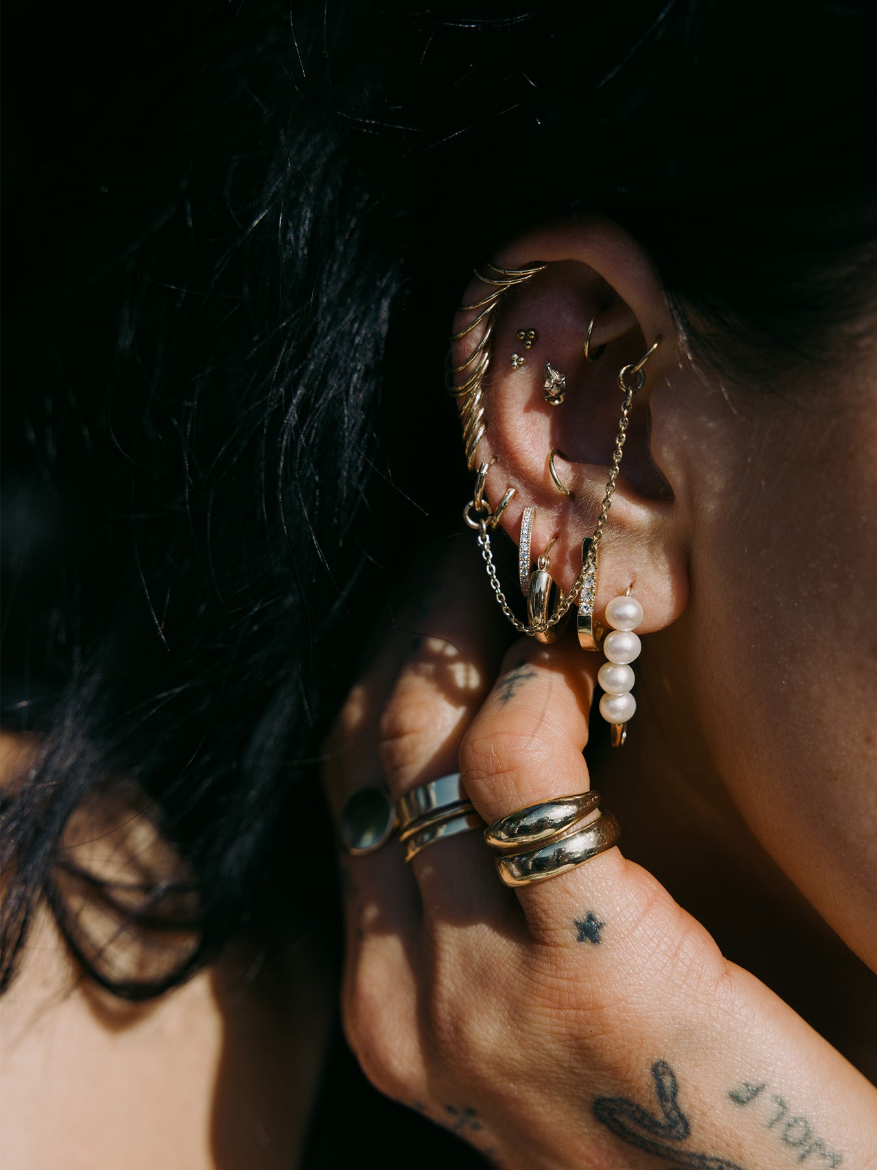 14kt Yellow Gold Pave Hoops pictured in models fourth piercing. Styled with other signature styles.