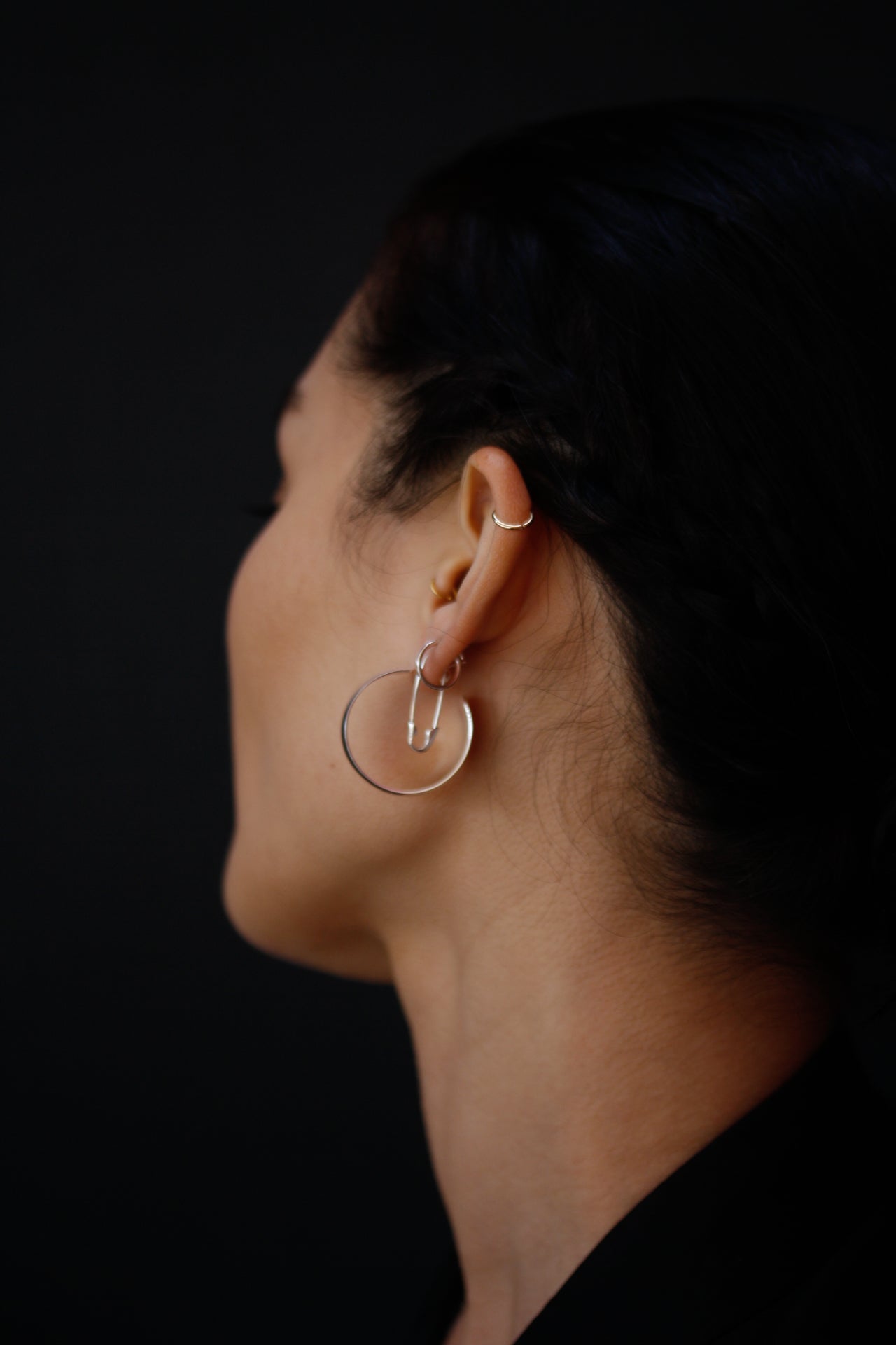 XL Dome Hoops pictured from side view on model. Black background. 