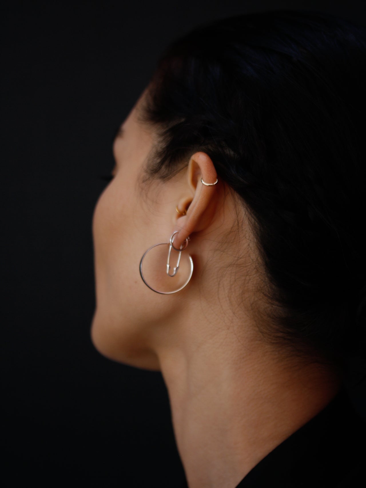 XL Dome Hoops pictured from side view on model. Black background. 