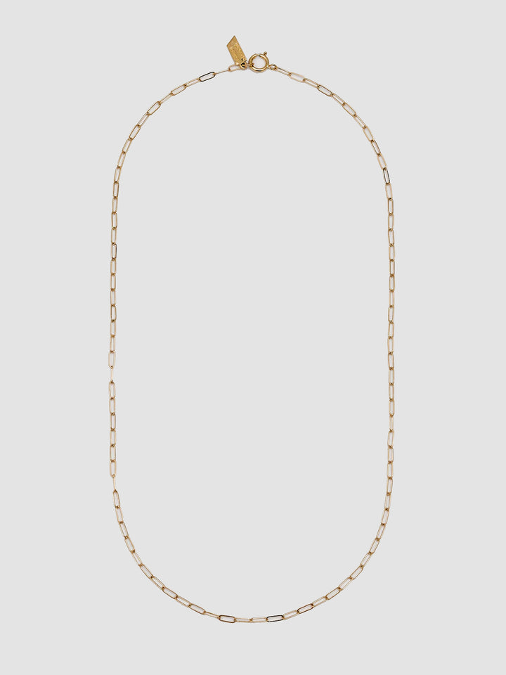 Gold chain necklace on a light gray background