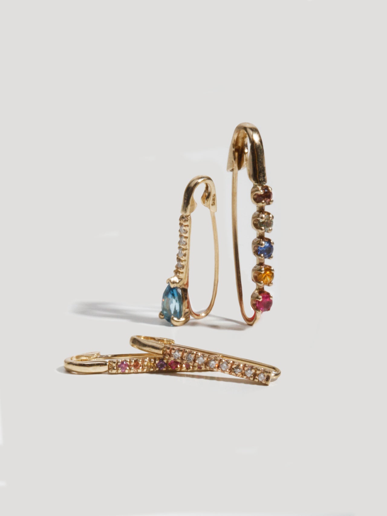 14kt Yellow Gold Mini Diamond Safety Pin pictured along side the Sunset Safety Pin. Also featured are the Mini Rainbow and Diamond Safety Pins. 
