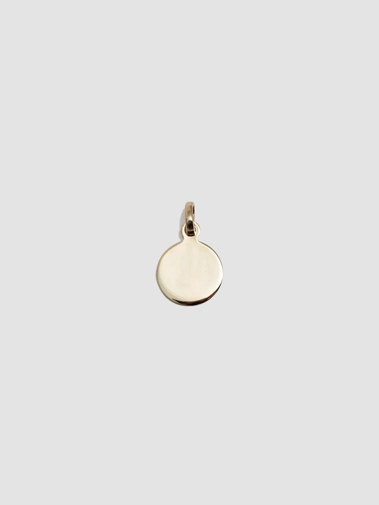 Gold pendant on a light gray background