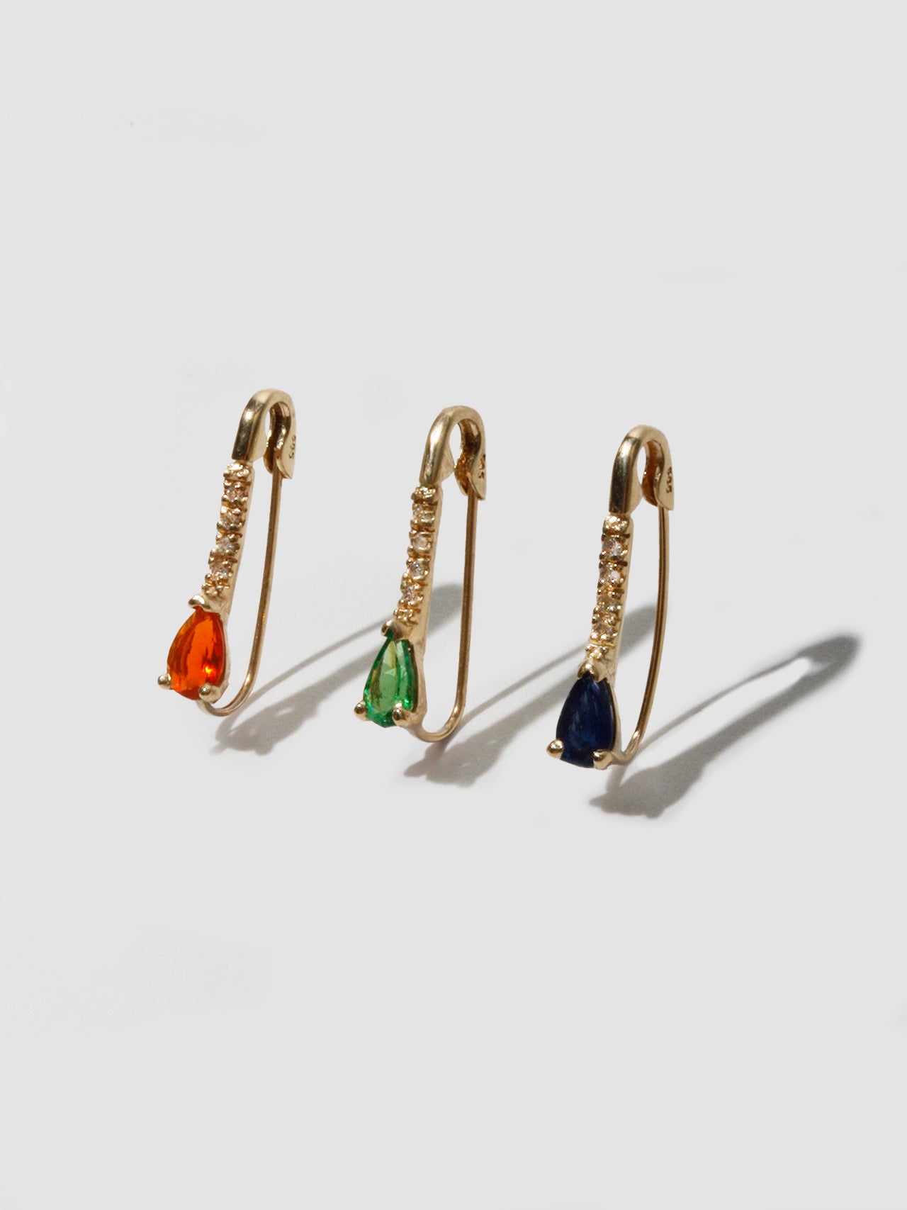 14kt Yellow Gold Mini Diamond Tsavorite Safety Pin pictured with the Fire Opal and Dark Blue Sapphire Safety Pins. 
