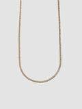 Gold chain necklace on a light gray background