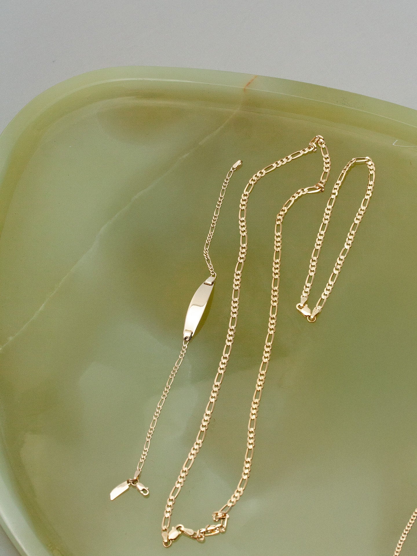 14kt Yellow Gold Solid Figaro Chain Bracelet pictured on tray. 
