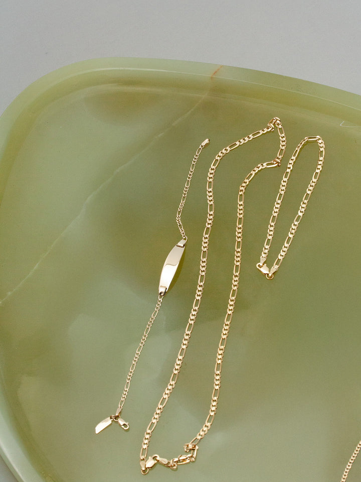 14kt Yellow Gold Solid Figaro Chain Bracelet pictured on tray. 