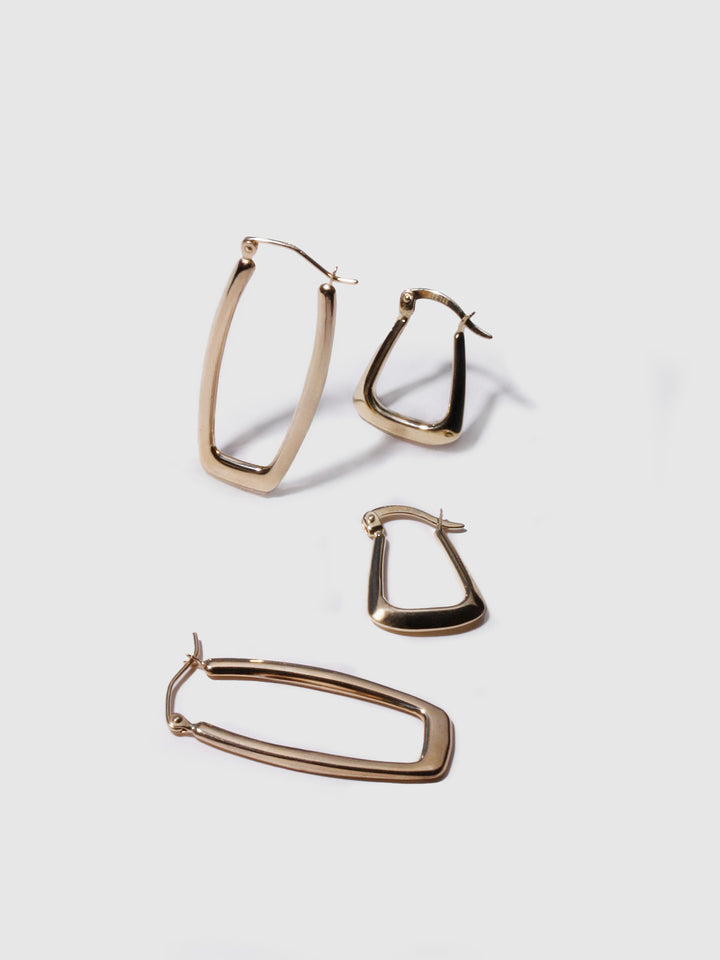 Flat lay of 14kt Yellow Gold Hoops Trifecta Hoops and Squoval Hoops.