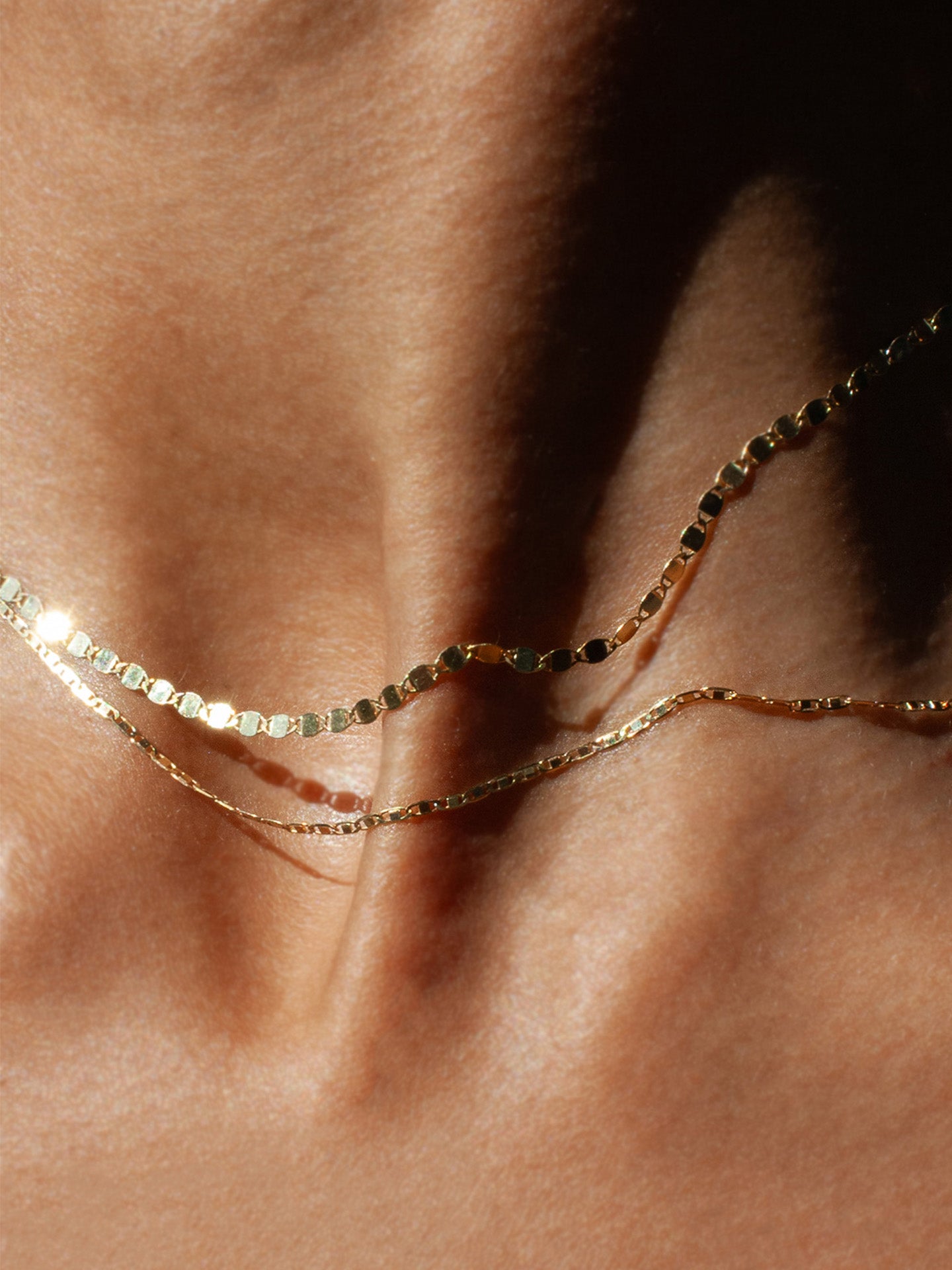 Sol Valentino Necklace pictured layered with the Baby Sol Valentino Necklace. Worn on models neck. Close up shot. 