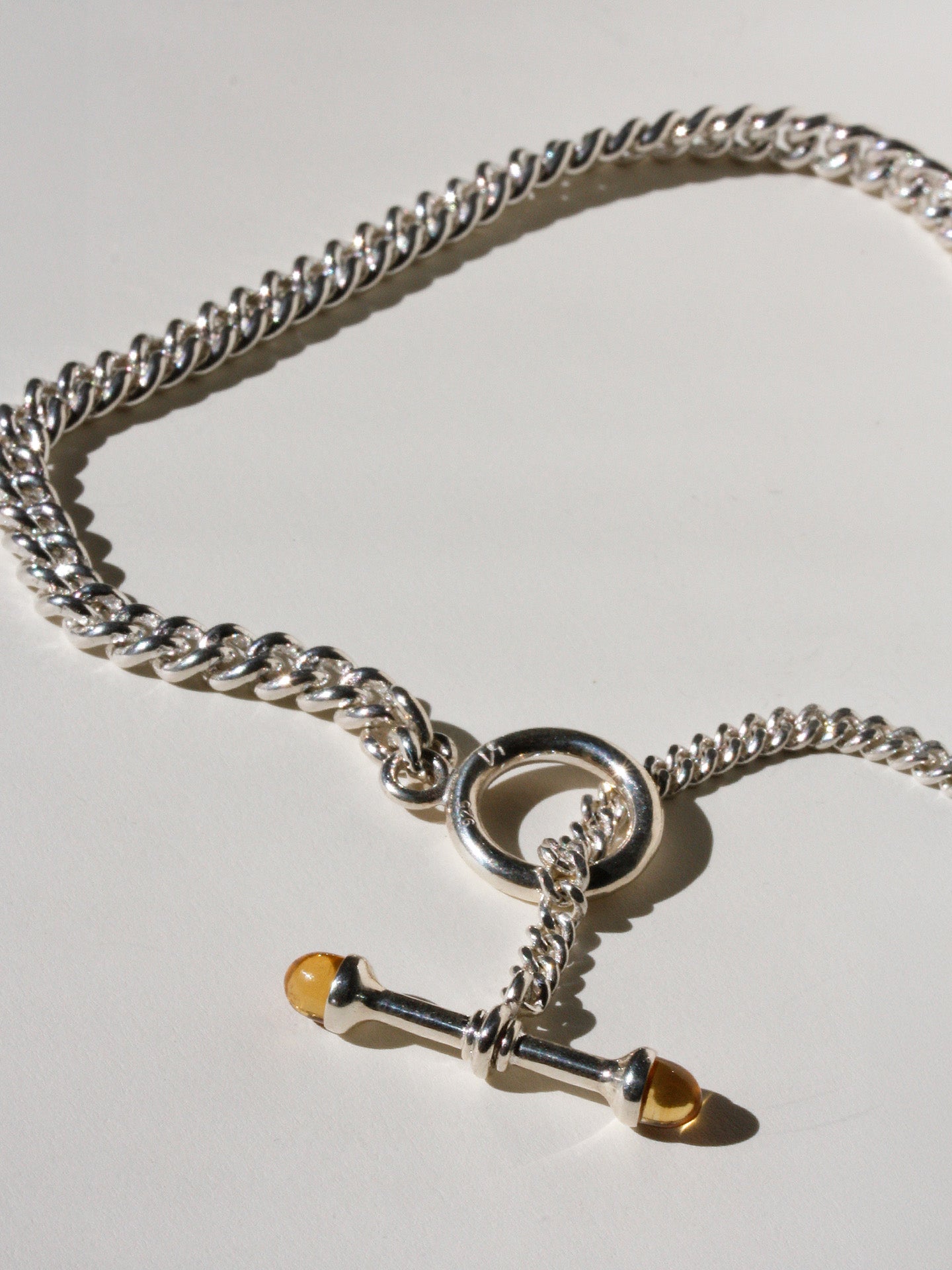 Sterling Silver Solid Scout Barbell Toggle Necklace pictured close up on light grey background. 
