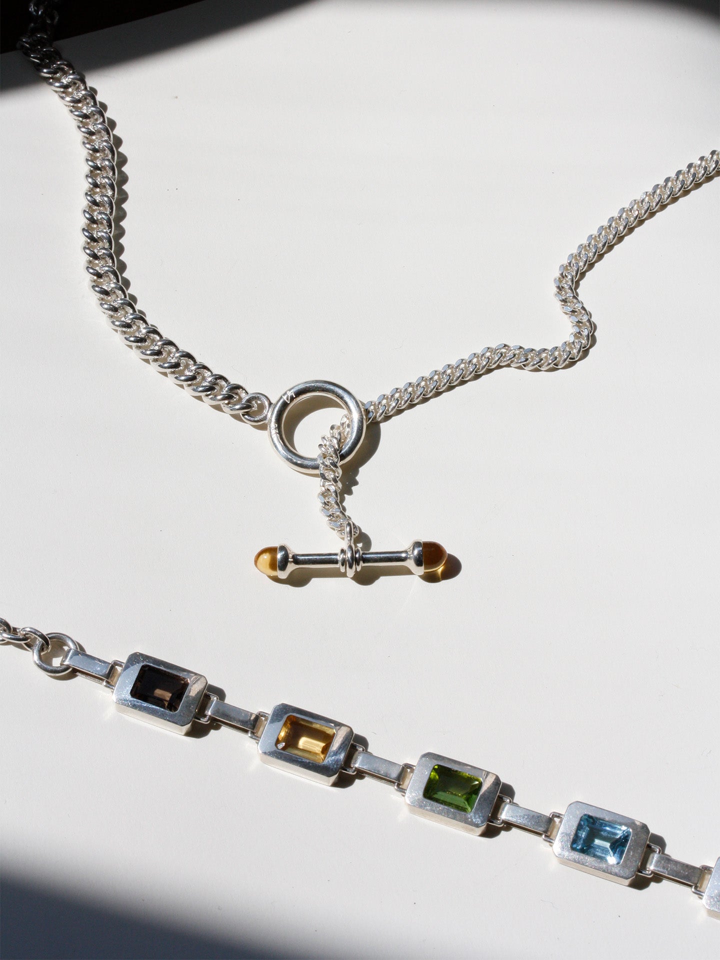 Flat lay of Sterling Silver Solid Scout Barbell Toggle Necklace pictured with the Roca Link Bracelet. 