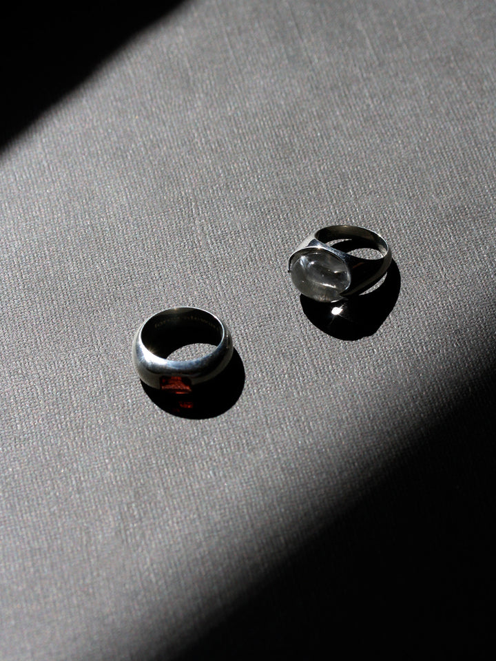 Two silver rings on a textured gray surface