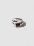 Silver ring with a red stone on a white background