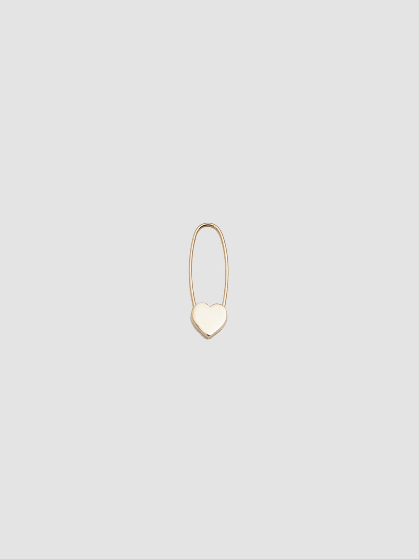 A single gold heart safety pin earring on a white background