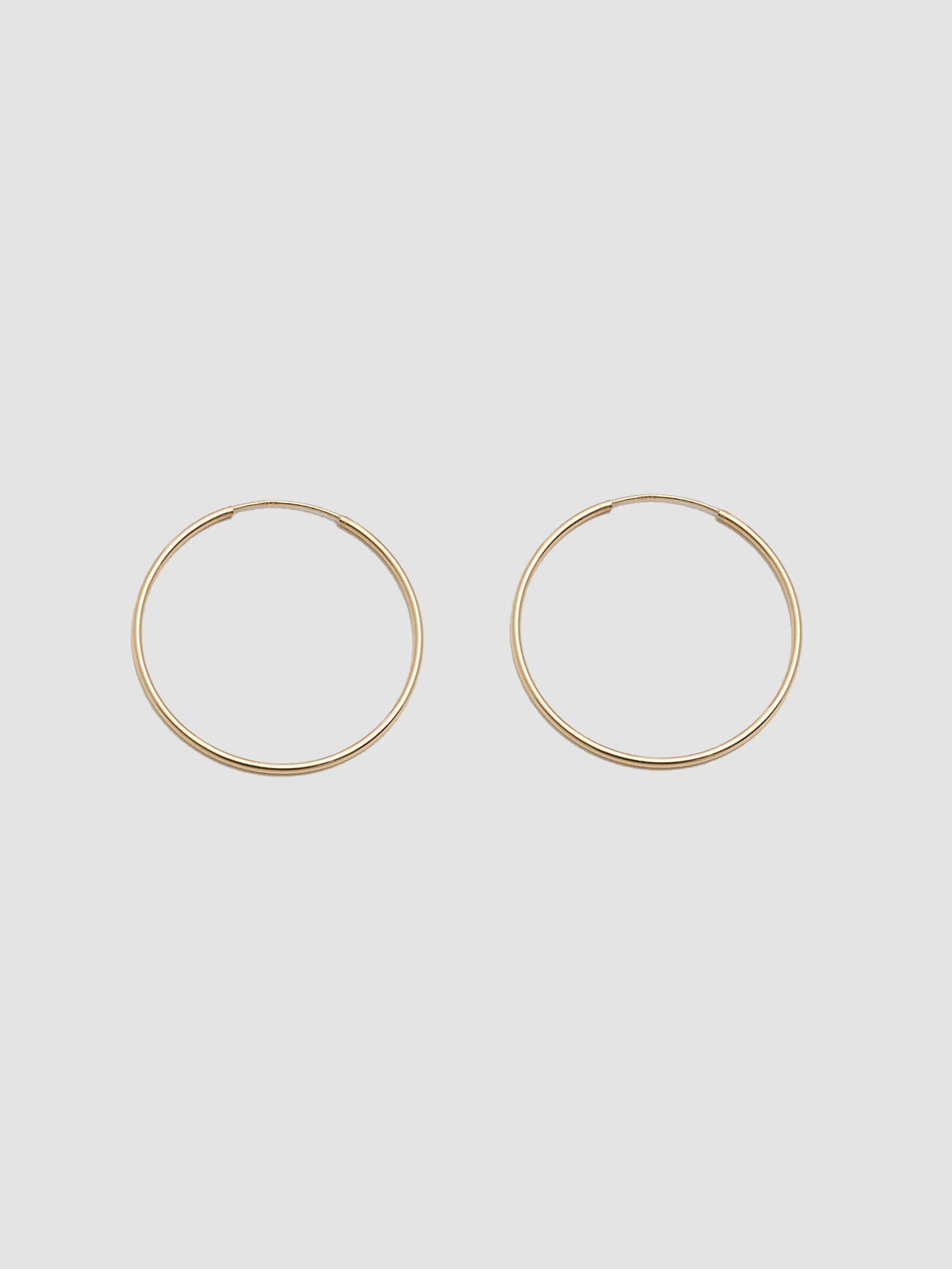 Product shot the Winona Hoops ( 14Kt Yellow Shiny Gold Hoops) Background: Grey paper 