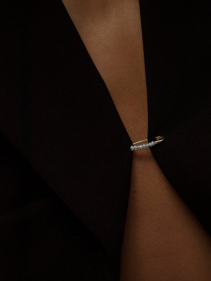 14Kt Yellow Gold Seed Pearl Safety Pin Earring worn as a pin on clothing.