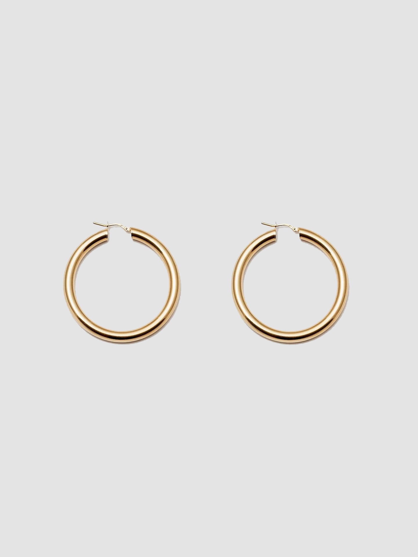 Product Shot of the Tru Hoops in Vermeil gold (Vermeil Hoops 49.5mm diameter 5mm thick) Background: Grey backdrop