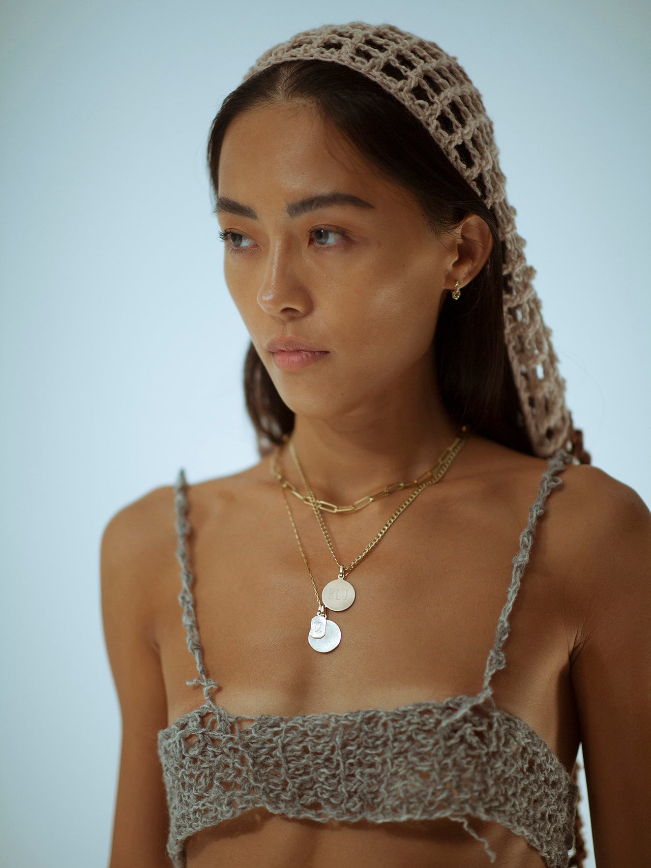 14Kt Yellow Gold Disk Pendant pictured on model. Hanging from chain along with other pendants.