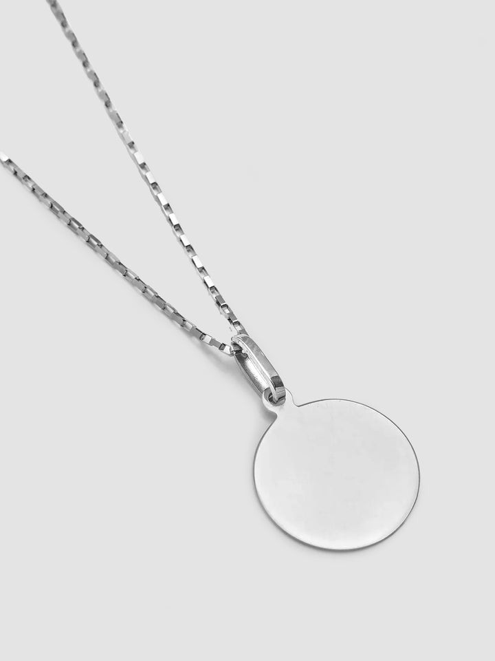 A sterling silver disk pendant attached to a silver chain, displayed against a white background.