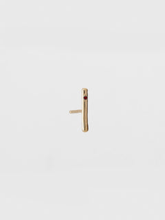 Gold bar earring on a light beige background