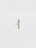 Gold bar earring on a light beige background