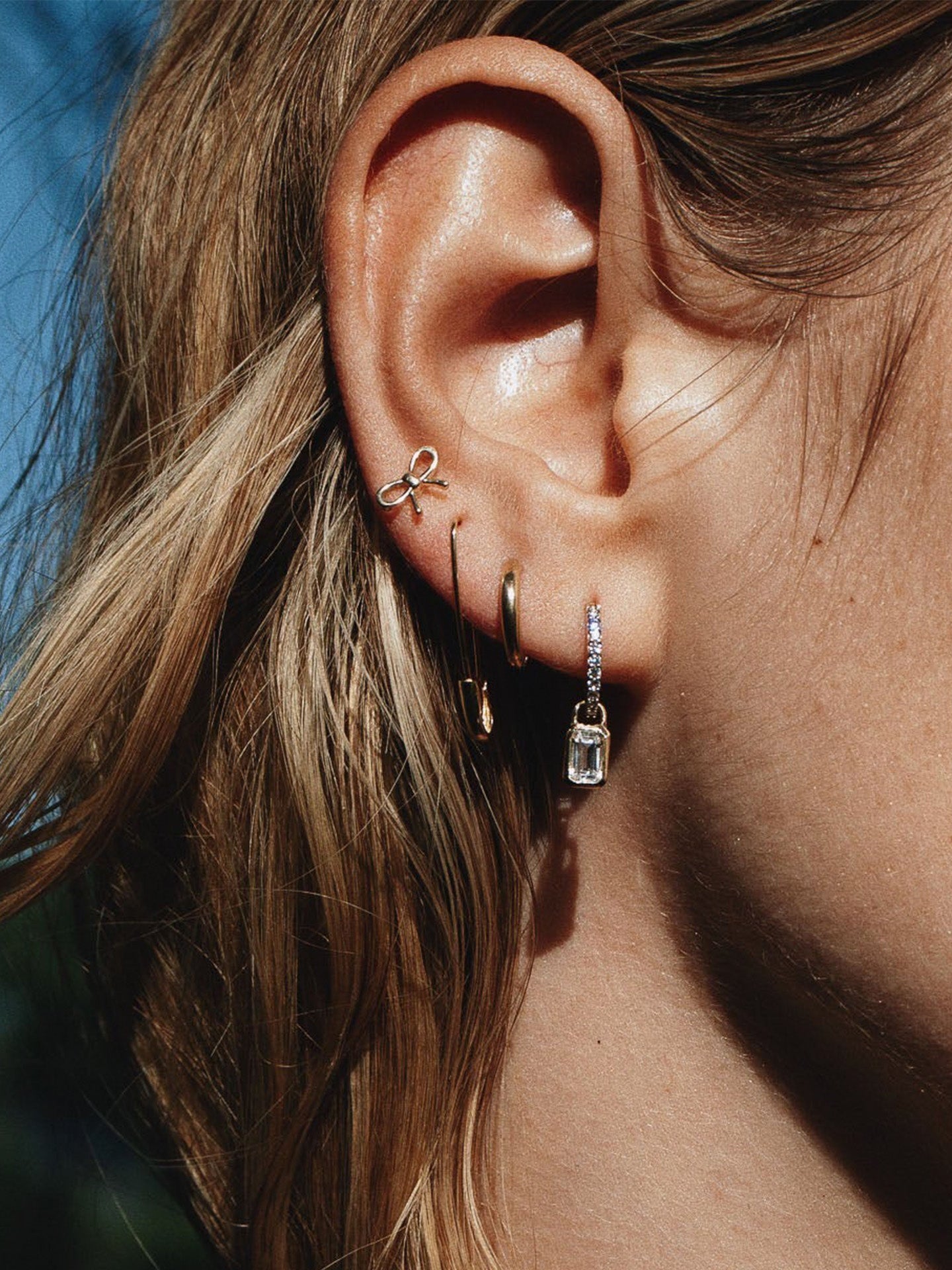 14kt Yellow Gold Mini Bow Studs pictured on models ear.