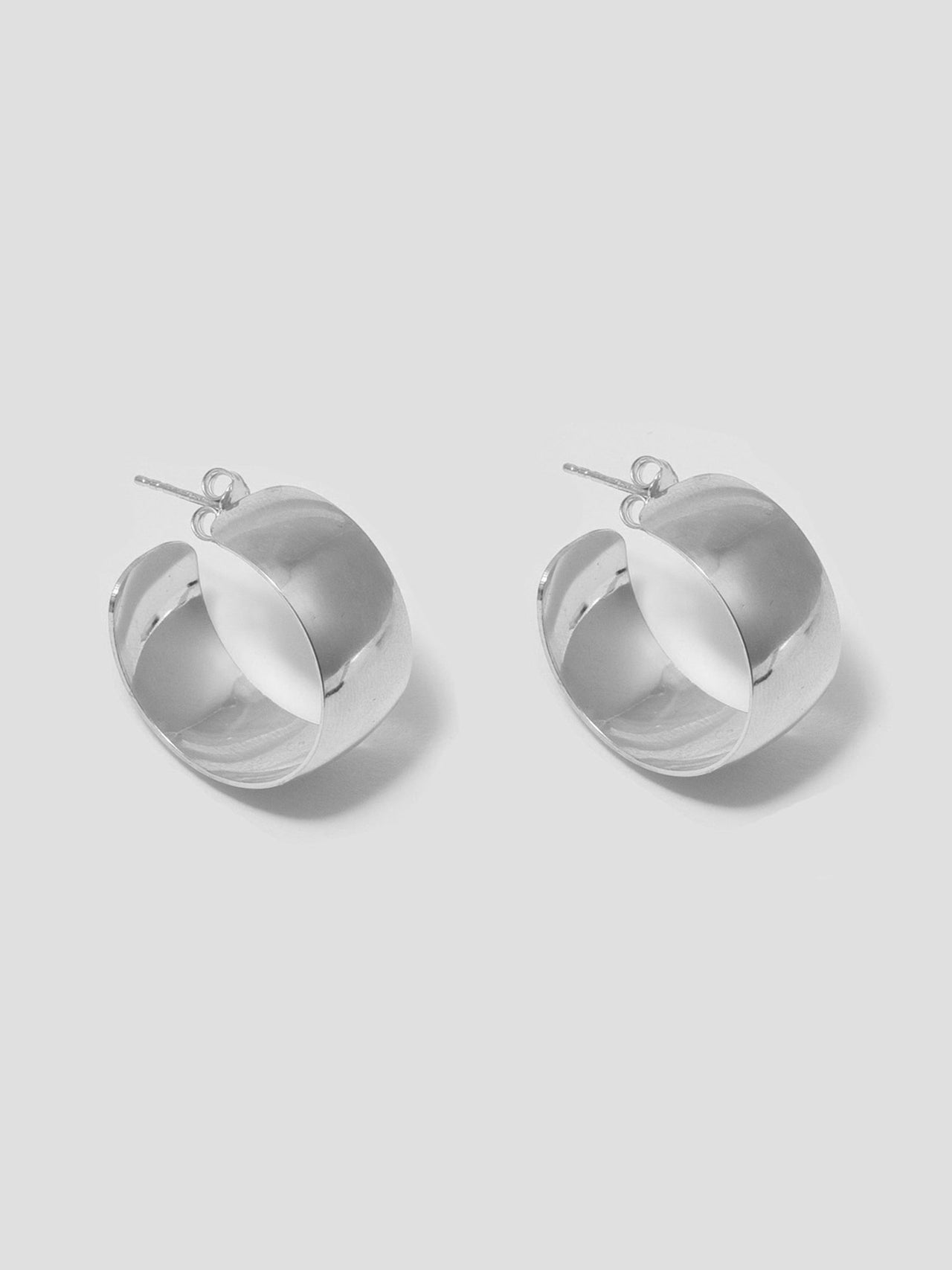 Product shot of the XL Dome Hoops(Sterling Silver Hoop Earrings 30mm Diameter 12mm Wide) Background: Grey backdrop