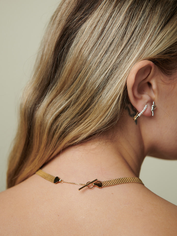 Vermeil Bizmark Chain Necklace pictured on model from back angel. Beige background.