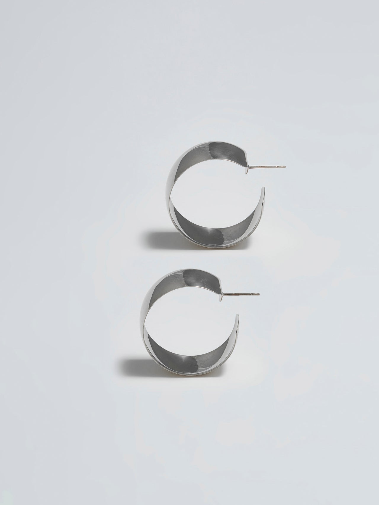 Product shot of the XL Dome Hoops(Sterling Silver Hoop Earrings 30mm Diameter 12mm Wide) Background: Grey backdrop