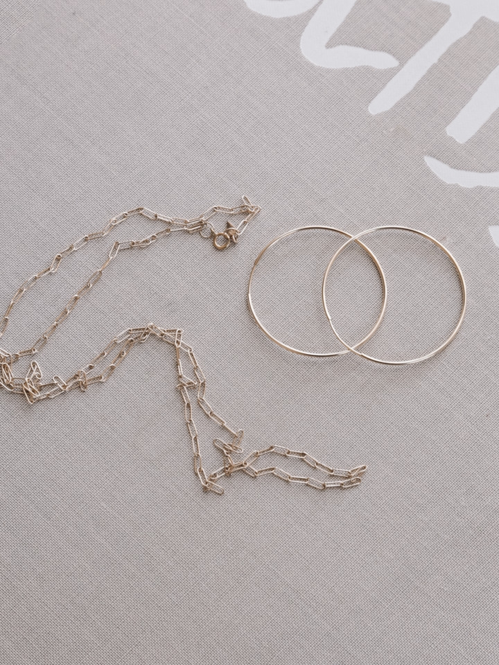 14Kt Yellow Gold Ultralight Infinity Hoops flat lay image.