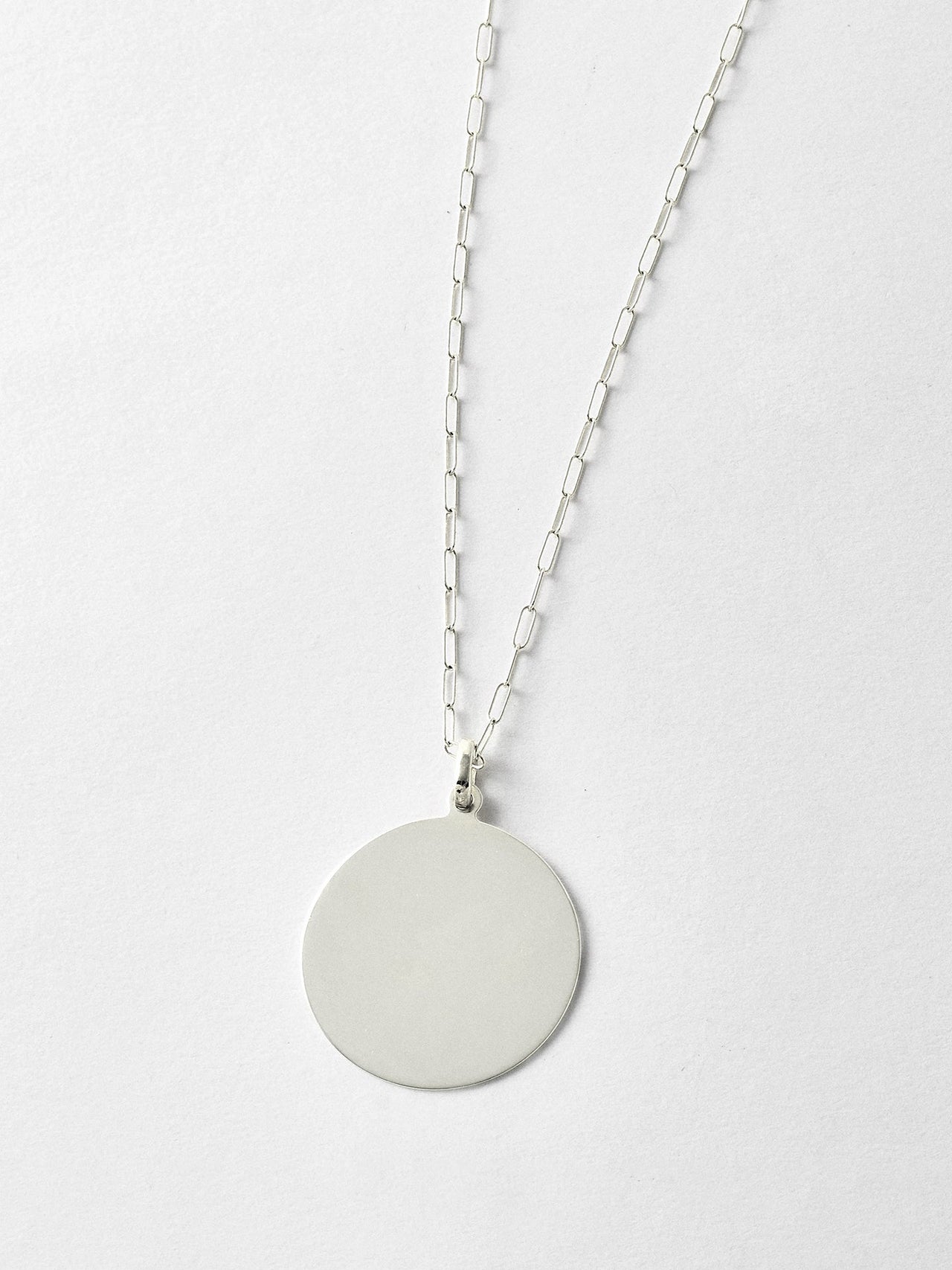 XL Sterling Silver Disk Pendant pictured on light grey background. Worn with the Long Link Chain.